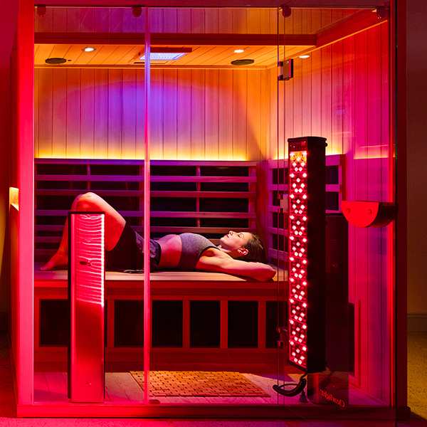 Red light filling the Clearlight Sauna with a person laying inside