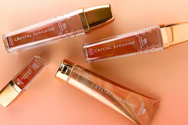 The Crystal Sunshine collection in warm bronze and gold tones arranged on a peach background.