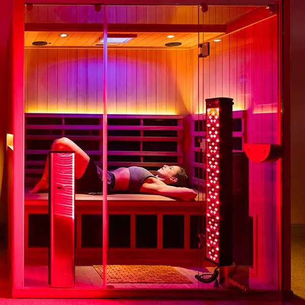 A person laying down in a red light therapy session.
